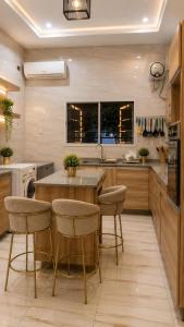 a kitchen with a large wooden table and stools at Halijomak Apartments in Abuja