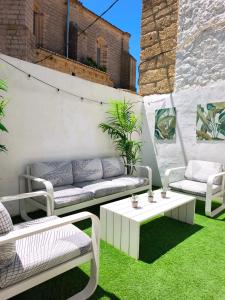 a patio with white furniture and green grass at Casa Nentis in Mucientes