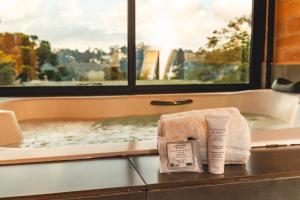 a bathroom with a bath tub with a window at DOM Hotel in Campos do Jordão +78 photos