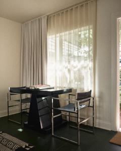 a room with a table and chairs and a window at Perroquet Hotel in Fort Lauderdale