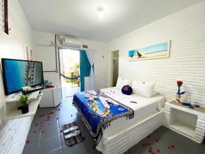 a bedroom with a bed and a flat screen tv at Pousada 3 Abelhas in Caucaia