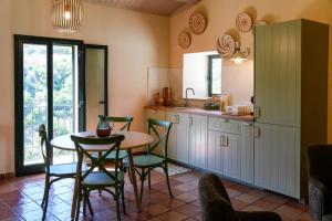 a kitchen with a table and chairs in a room at Lues Garden in Ragusa