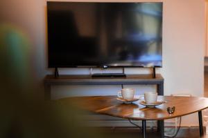 a coffee table with two cups and a tv at Lues Garden in Ragusa