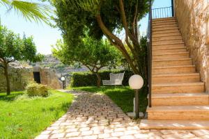 a set of stairs leading up to a house with a bench at Lues Garden in Ragusa