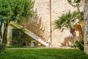 a stone building with stairs on the side of it at Lues Garden in Ragusa +12 photos