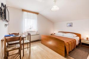 a bedroom with a bed and a table and a desk at Turistična kmetija Široko in Tolmin