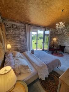 a bedroom with a large bed and a large window at Domki nad rzeką Ełk in Prostki