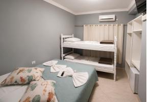 a bedroom with two bunk beds with towels on them at Pousada Ilha do Itacolomi in Penha