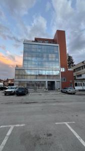 a large building with cars parked in a parking lot at Апартамент 503 in Samokov