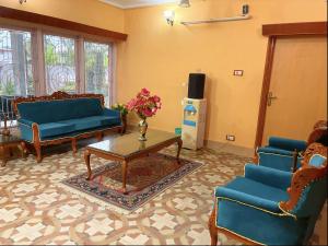 a living room with blue couches and a coffee table at Zakiyas Homestay in Srinagar