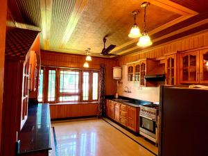 a large kitchen with wooden cabinets and a stove at Zakiyas Homestay in Srinagar