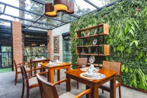 a restaurant with tables and chairs and a green wall at DOM Hotel in Campos do Jordão