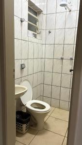 a bathroom with a toilet and a sink at Hotel Olympia in Cláudio