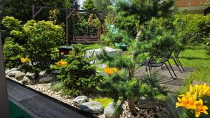 a garden with a bench and trees and flowers at Dom na Pięknej Ustroń in Ustroń