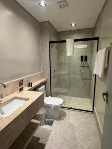 a bathroom with a shower and a toilet and a sink at Class Hotel Americana in Americana