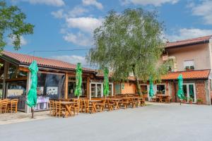 a restaurant with wooden tables and green umbrellas at Turistična kmetija Široko in Tolmin
