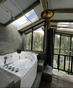 a bathroom with a large tub in a room with windows at Aldealma in Pisac +56 photos