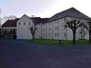 a large white building with trees in front of it at Hôtel Ibis Nevers in Nevers