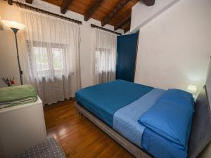 a bedroom with a blue bed and a window at Al centro e vicina al lago in Farra dʼAlpago