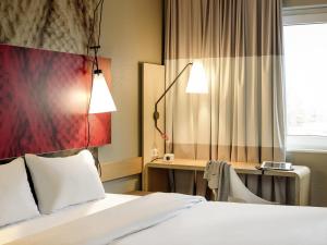 a hotel room with a bed and a desk and a window at ibis Gent Centrum St. Baafs Kathedraal in Ghent +59 photos