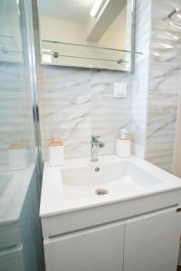 a white bathroom with a sink and a mirror at V&G Apartments in Kyustendil +20 photos