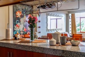 a kitchen counter with a vase of flowers on it at El Balcón del Sol - Dpto Céntrico con Vistas Perfectas in Cusco