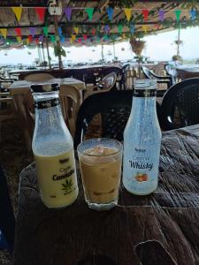 two bottles of orange juice and a drink on a table at Cabaña la fundadora in San Luis