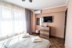 a bedroom with a bed and a tv on a wall at V&G Apartments in Kyustendil