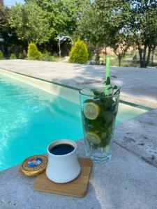 a cup of coffee and a glass of drink next to a pool at Near Yerevan Serlinhouse in Oshakan