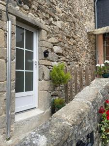 a stone house with a window and a fence at Studio de caractère en pierre in Coutances