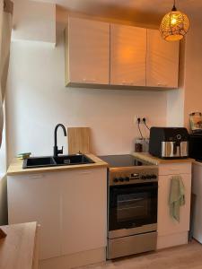 a small kitchen with a sink and a stove at Studio de caractère en pierre in Coutances