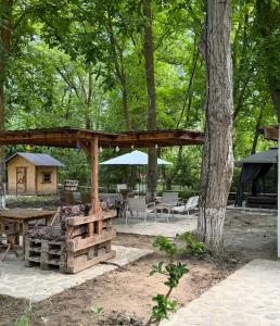 a wooden pavilion with tables and chairs and a tree at Lisan VIllas in Nabran
