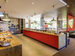 a kitchen with a red counter in a restaurant at ibis Augsburg Koenigsplatz in Augsburg