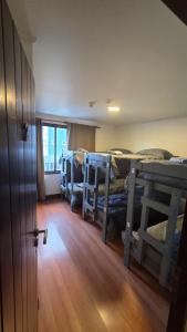 a room with three bunk beds and a wooden floor at Torre al Sur in Ushuaia +14 photos