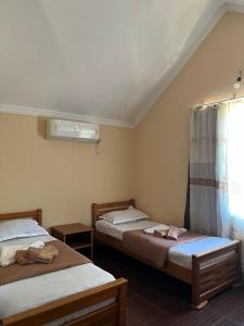 a room with two beds and a window with at Liza's house - Block A in Ureki