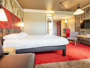 a hotel room with a large bed and a kitchen at ibis Le Havre Centre in Le Havre +131 photos