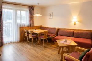 a restaurant with a couch and a table and chairs at Das Weber in Sankt Jakob in Defereggen +20 photos