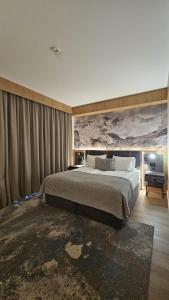 a bedroom with a large bed with a painting on the wall at Azuga Ski & Bike Resort in Azuga +23 photos
