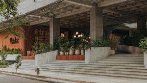 a building with stairs and potted plants in front of it at Wake Living in Medellín