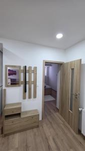 a living room with a wooden table and a door at Apartmán U splavu Luhačovice in Luhačovice