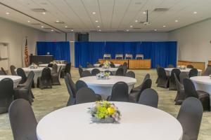 a conference room with white tables and chairs at Beachside Hotel & Suites Cocoa Beach - Port Canaveral in Cocoa Beach +69 photos