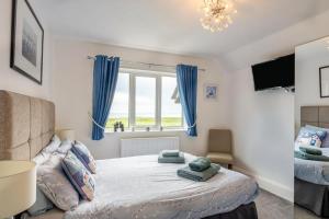 a bedroom with a bed with blue curtains and a window at 1 Bed in Filey oc-77710 in Hunmanby