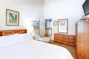 a bedroom with a white bed and a tv at Crestview 36 in Mammoth Lakes