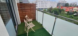 a balcony with two chairs sitting on the grass at Andersena 43 Ząbki in Ząbki