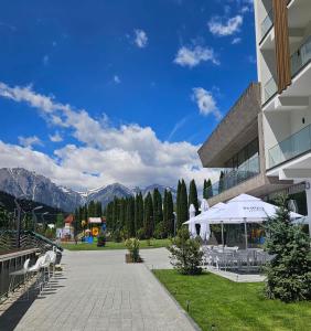 a building with a patio with tables and chairs at Azuga Ski & Bike Resort in Azuga