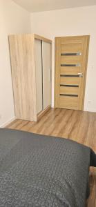 an empty room with a bed and wooden doors at Andersena 43 Ząbki in Ząbki
