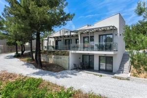 a white house with trees in front of it at Pine Suites in Potos +42 photos
