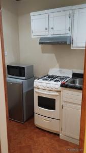 a kitchen with a stove and a microwave at Cómodo departamento equipado in Chihuahua