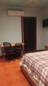 a bedroom with a desk and a chair next to a bed at Cómodo departamento equipado in Chihuahua