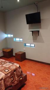 a room with two beds and a flat screen tv at Cómodo departamento equipado in Chihuahua
